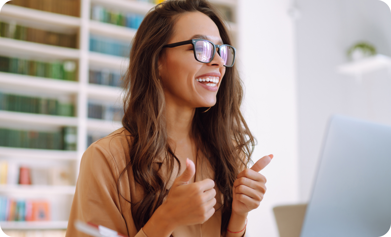 Mujer haciendo gesto de aprobación frente al computador.