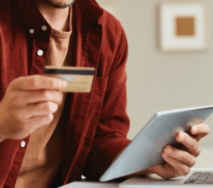 Joven realizando una compra online con su tarjeta de crédito.