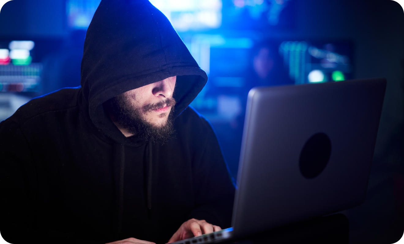 Young person in front of a computer hiding their identity.